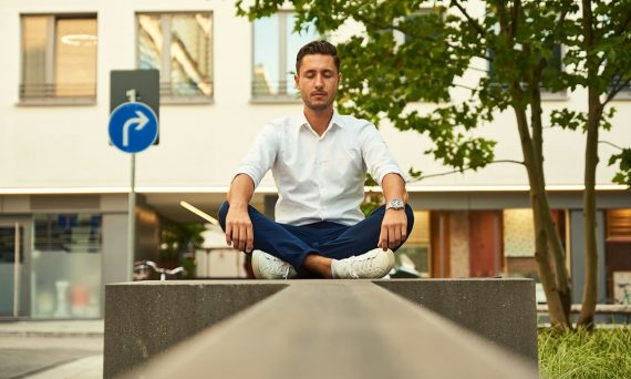 Young business man meditating during lunch break